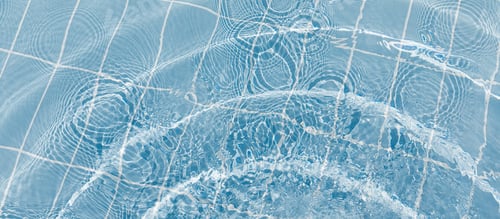 Preview: Clear water surface with ripple wave splashes and drops in swimming pool. Abstract turquoise