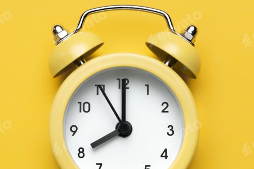 Preview: Yellow round alarm clock on the yellow background.