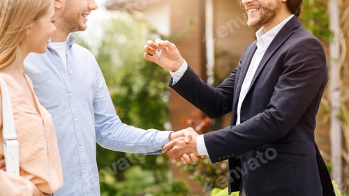 Preview: Unrecognizable real estate broker giving house key and shaking hands with new home owners near their