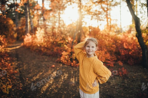 Preview: Cute girl enjoying beautiful autumn sunset in a beautiful forest.