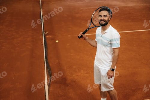 Preview: Smiling, positive facial expression. Man is playing tennis indoors in the hangar