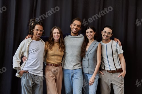 Preview: group portrait of positive multiethnic colleagues in office on black backdrop, unity in business