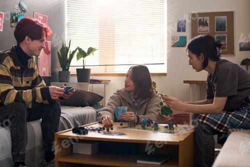 Preview: Three Smiling Teenagers Playing Board Game