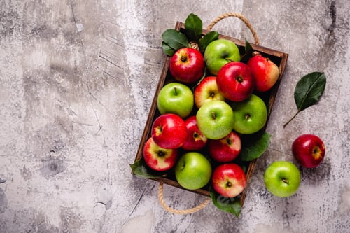 Preview: Ripe red and green apples in wooden box.