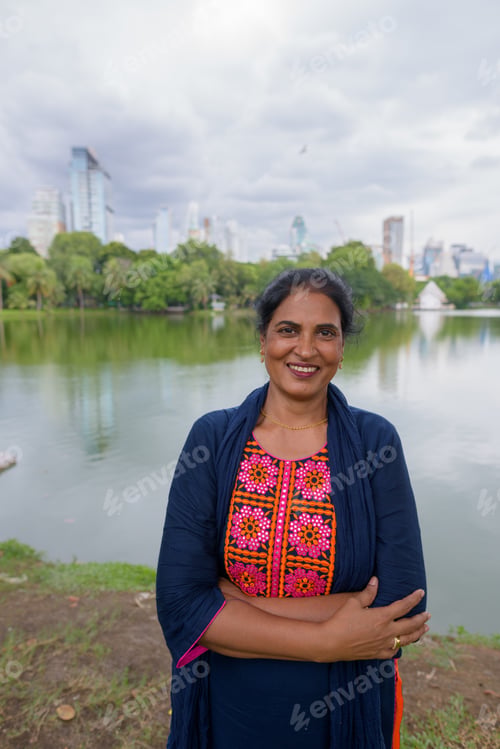 Preview: Portrait of mature Indian woman smiling at park