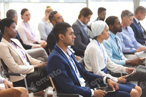 Preview: Side view of diverse business people attending a business seminar in office building