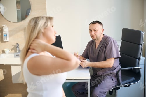 Preview: Healthcare professional receiving patient with neck pain in his office