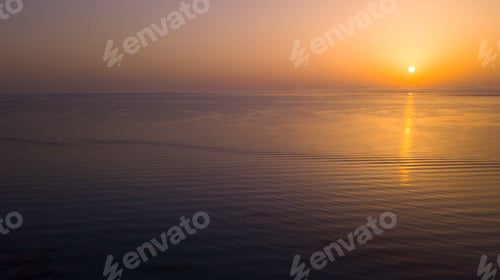 Preview: Sunset view on water ocean surface with orange sun in background. Beautiful dusk landscape