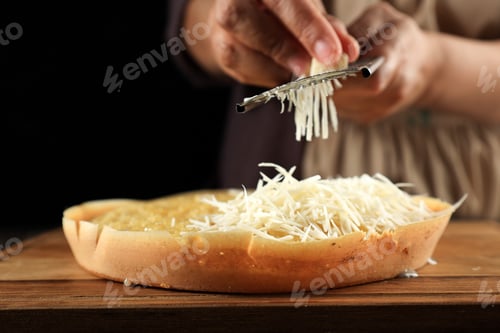 Preview: Woman Hand Grating Cheese to the Martabak Manis Terang Bulan at Wooden Table