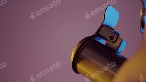 Preview: Extreme close up of steel kettle closed spout with golden light reflection on its surface. Action. A