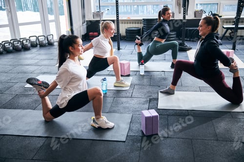 Preview: Cheerful young women taking their time to stretch muscles