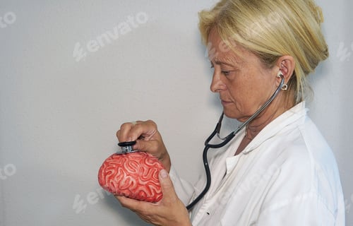 Preview: Female doctor puts the stethoscope on a rubber brain