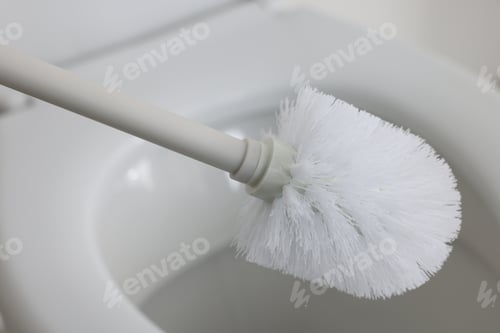 Preview: Cleaning toilet bowl with white brush, closeup