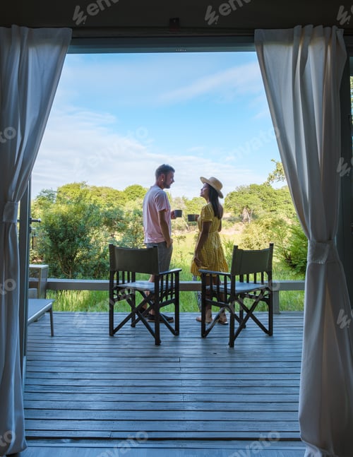 Preview: couple on safari in South Africa, Asian women and European men at a tented camp lodge during safari