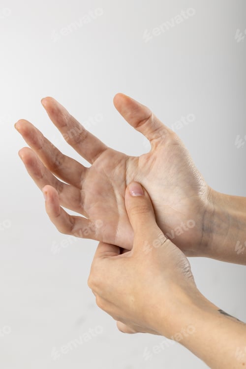 Preview: Vertical close up of hands of caucasian woman massaging her palm on white background with copy space