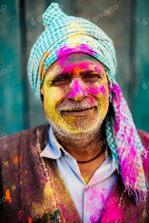 Preview: Man smiling with face covered in Holi festival colors