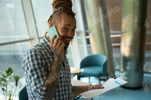 Preview: Smiling guy with dreadlocks is on the phone