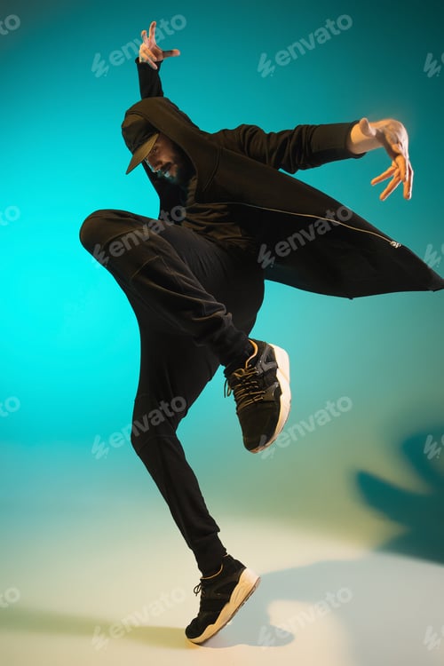 Preview: The silhouette of one hip hop male break dancer dancing on colorful background