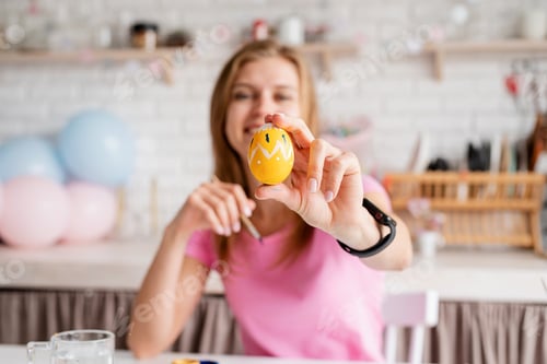 Preview: Woman coloring Easter eggs in the kitchen