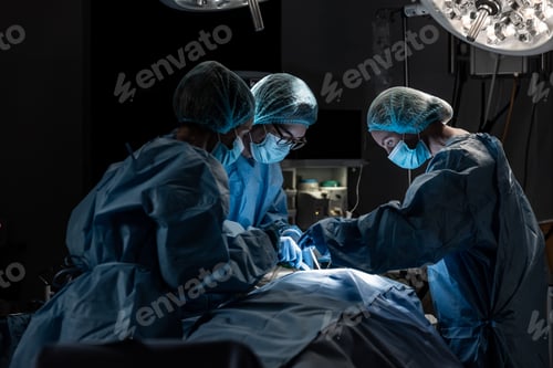 Preview: Diverse group of male and female surgeons in operating theatre wearing face masks performing surgery