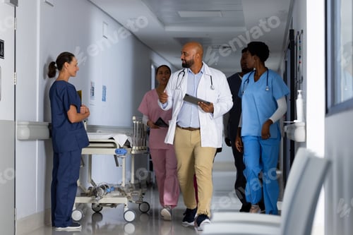 Preview: Diverse doctors discussing work and walking through corridor at hospital