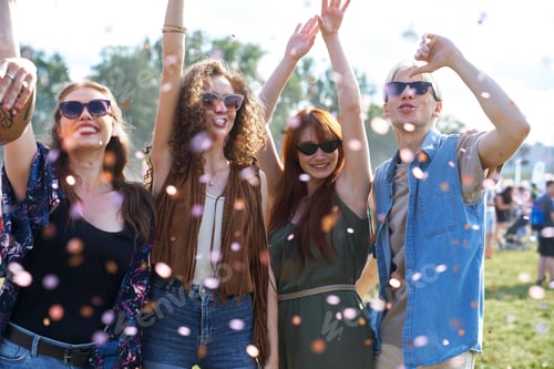 Preview: Group of young caucasian friends dancing and having fun on music festival among confetti