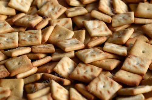 Preview: A lot of small cookies are square shaped. A pattern of a yellow salt cracker. Background