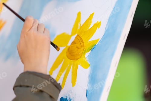 Preview: Child's hands drawing flowers on white sheet of paper. Top view. Children's and Earth day concept