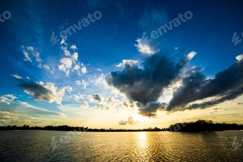 Preview: Golden Sunset Over Water with Dramatic Sky