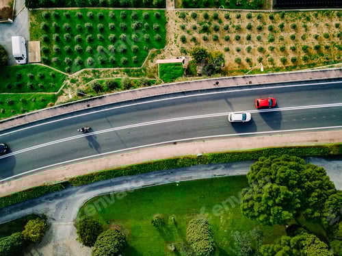 Preview: Aerial view of the asphalt road with cars going among the agricultural fields in Italy