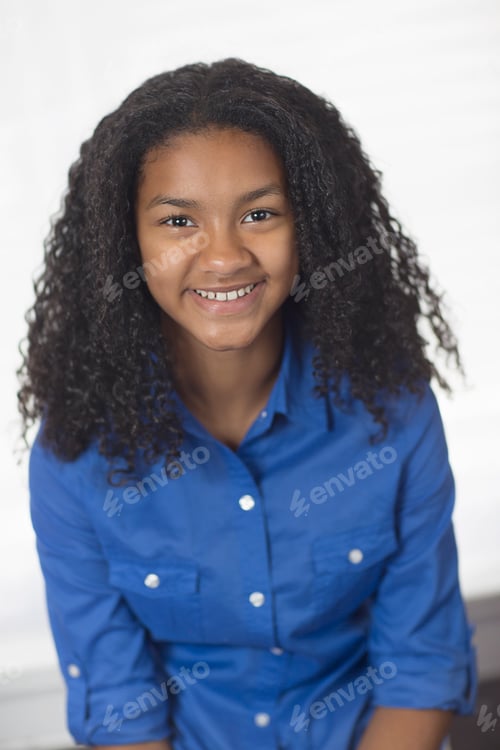 Preview: Portrait of girl with curly black hair looking at camera smiling