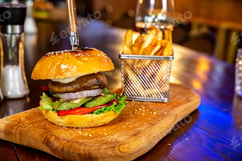 Preview: Serving of a delicious burger with French fries on a wooden boar