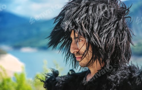 Preview: A Georgian man in a hat against the background of mountains and the sky. Selective focus.