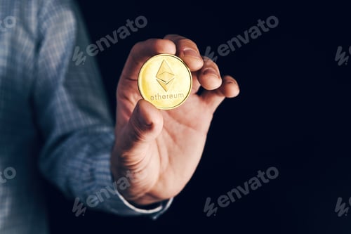 Preview: Businessman holding Ethereum cryptocurrency coin