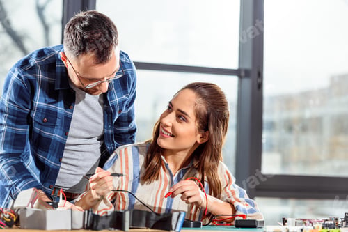 Preview: Team of engineers checking circuit board with multimeter