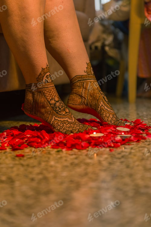 Preview: a person with tattoo designs on her feet standing next to a flower arrangement