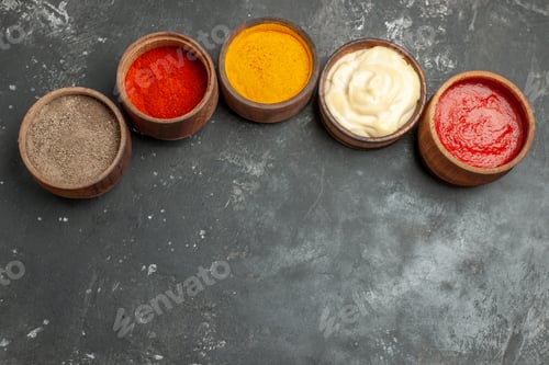 Preview: Above view of set for sauces containing different spices mayonnaise and ketchup on gray background