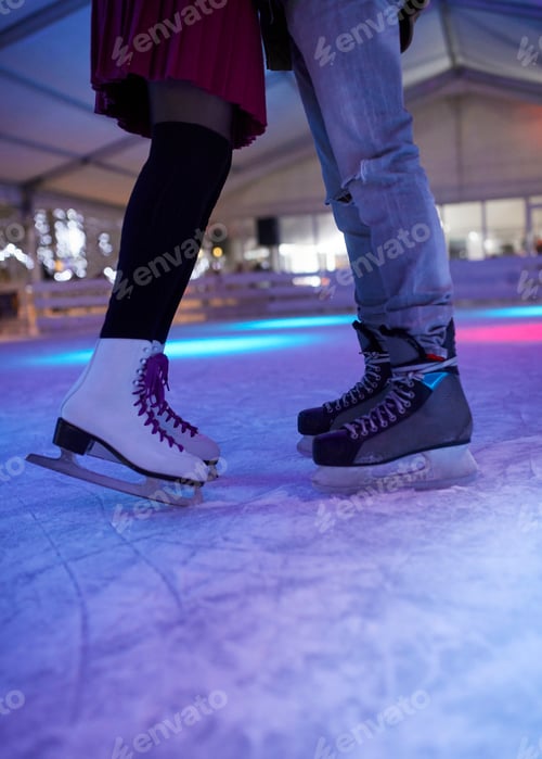 Preview: Legs of couple wearing ice skates standing on an ice rink