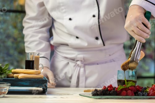 Preview: Hand with tongs holding biscuit