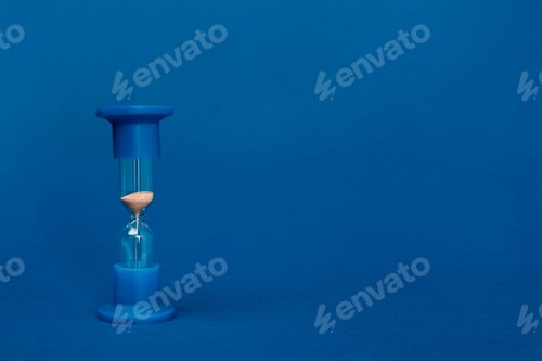 Preview: bright and colorful hourglass on blue background with copy space