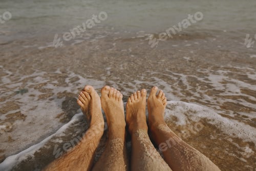 Preview: Couple wet feet in sand close up on sunny beach with waves