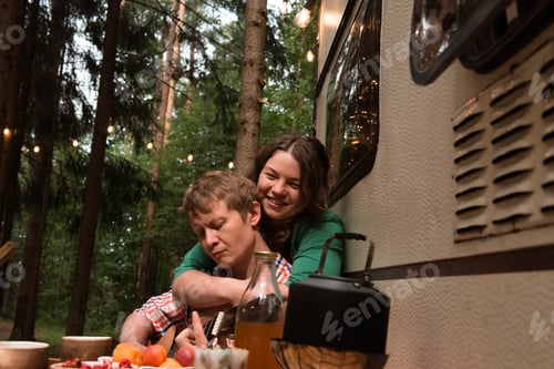 Preview: Couple Embracing at Campground Beside a Camper