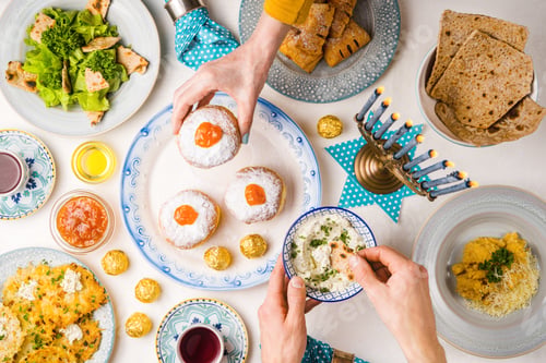 Preview: Festive feast on Hanukkah, table setting, hands over table