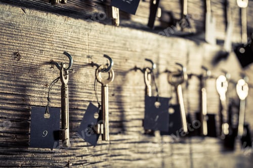 Preview: Closeup of old keys for hotel rooms on wooden wall