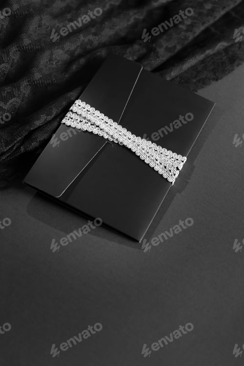 Preview: black envelope mockup, shot from the top on a black background with copy space.