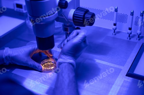 Preview: Laboratory technician studying embryos growth under microscope
