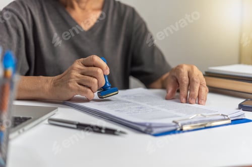 Preview: Woman stamping approval of work finance banking