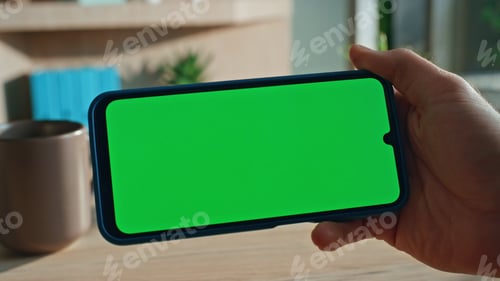 Preview: Finger tapping horizontal chroma key mobile phone at remote office close up.