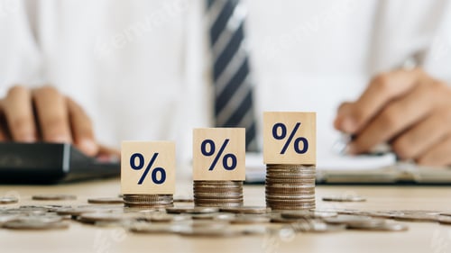 Preview: Interest rate concept.Wooden block with percentage symbol on stack of coins.