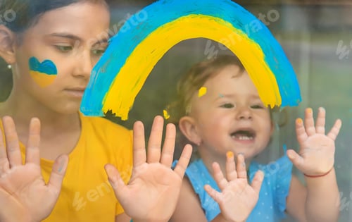 Preview: Children on the window painted a rainbow Ukraine peaceful sky. Selective focus.